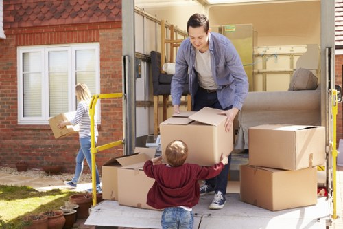 Moving helper carrying a sofa through a Brent property