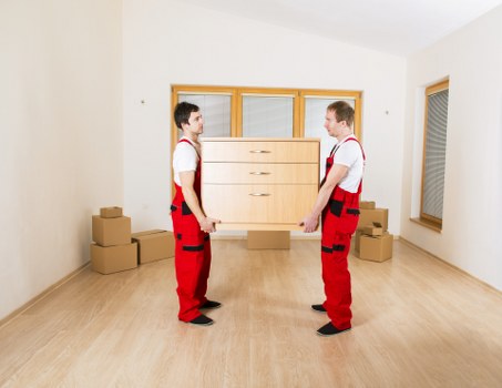 Removal crew carrying furniture through a Brent home